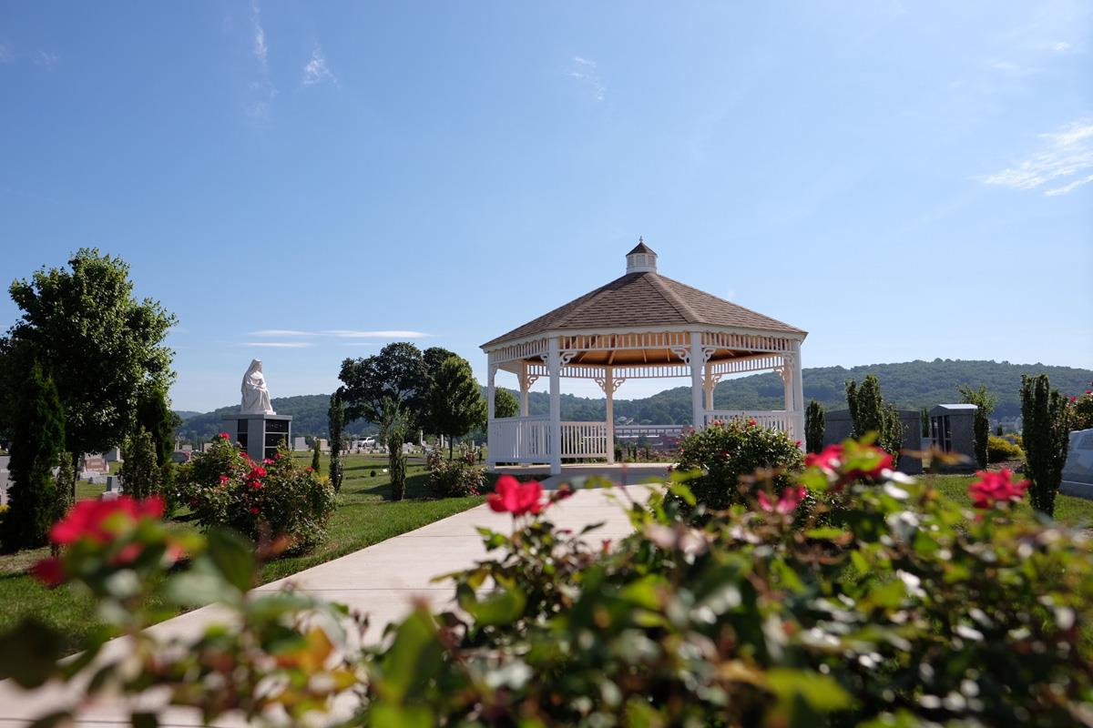 White Gazebo surrounded by pink rose bushes