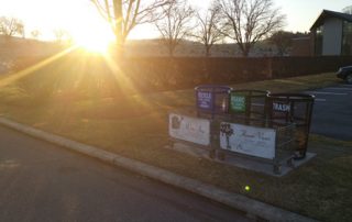 Bright sun over colored recycling bins