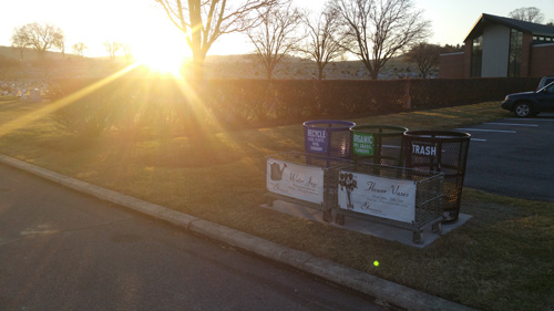 Bright sun over colored recycling bins